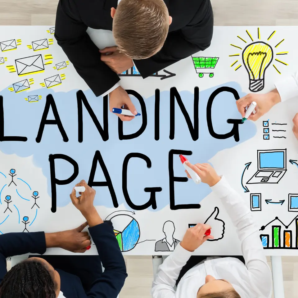 Team of professionals brainstorming around a table with the words “Landing Page” and digital marketing icons drawn on it